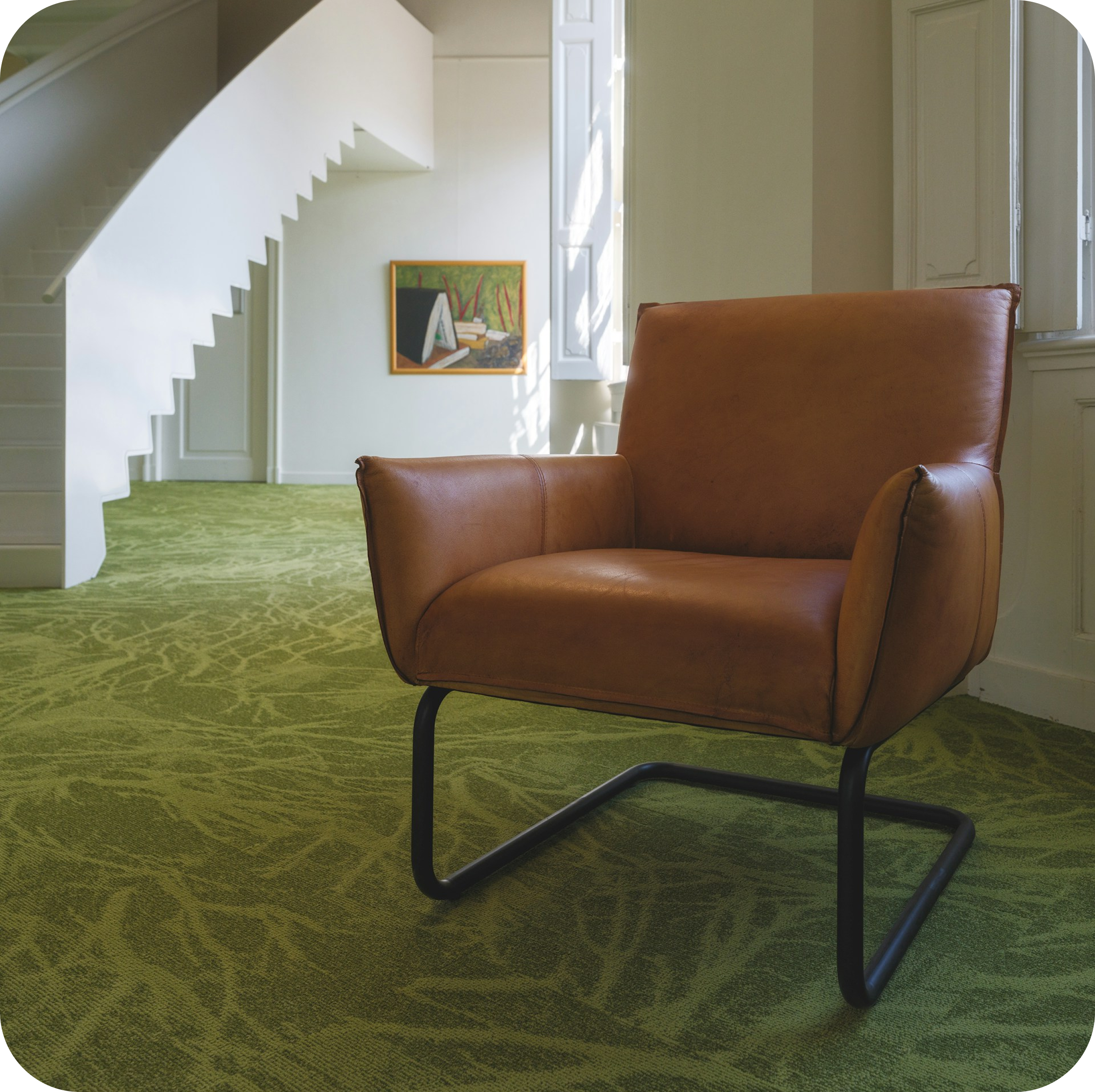 Brown leather cantilever chair on green carpet near staircase